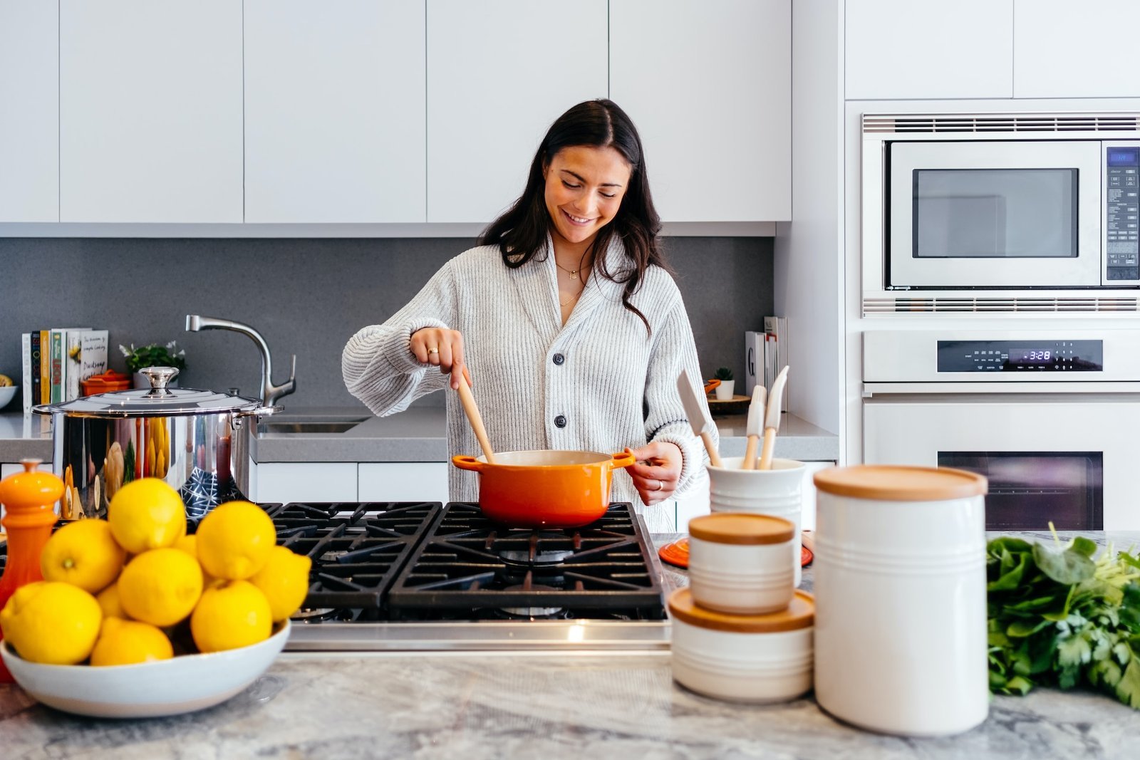 A woman cooking in a large white kitchen