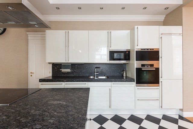 A white kitchen with gray affordable countertop materials