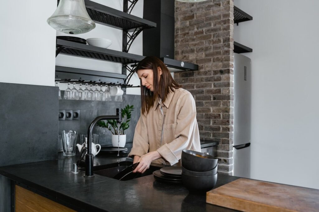A woman cleaning the dishes in a modern kitchen