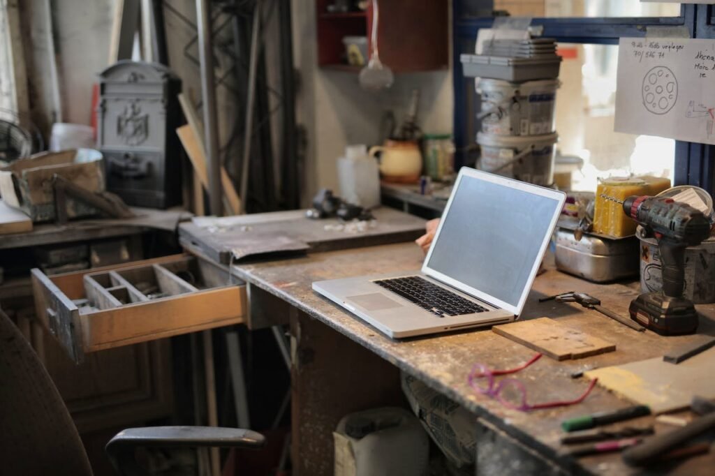 A laptop on a table in the garage converted into a workshop