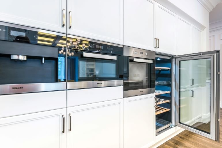 Modern kitchen with built-in appliances and sleek cabinetry showcasing efficient storage solutions.