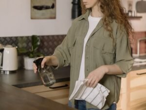 Woman wiping down brown kitchen countertop