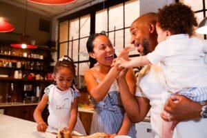 Happy family of 4 eating on a white kitchen countertop.
