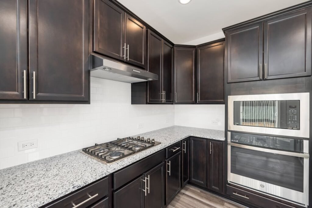 Modern kitchen with black cabinets, marble counter